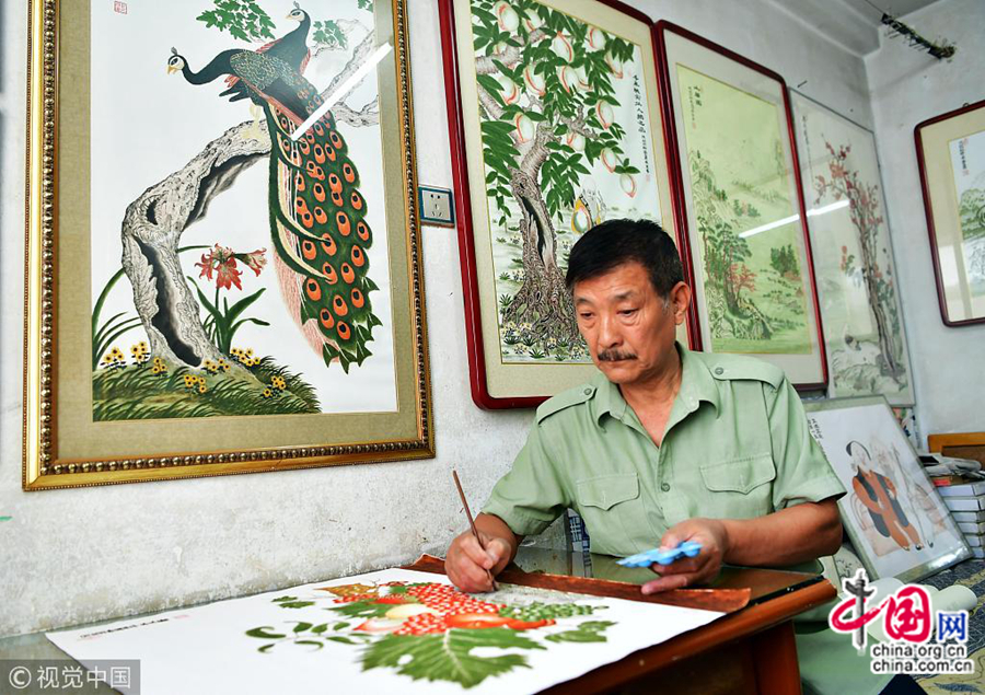 На фото: 10 октября, в г. Шицзячжуан провинции Хэбэй, 65-летний старик Пэн Миньсинь занимается живописью с растиркой из камня. 