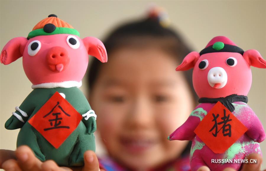 Ребята из детского сада в одном из поселков уезда Июань провинции Шаньдун /Восточный Китай/ приготовили к грядущему празднику Весны -- Новому году по традиционному лунному календарю -- яркие игрушки из пластилина и соленого теста в виде символа наступающего года Свиньи. 