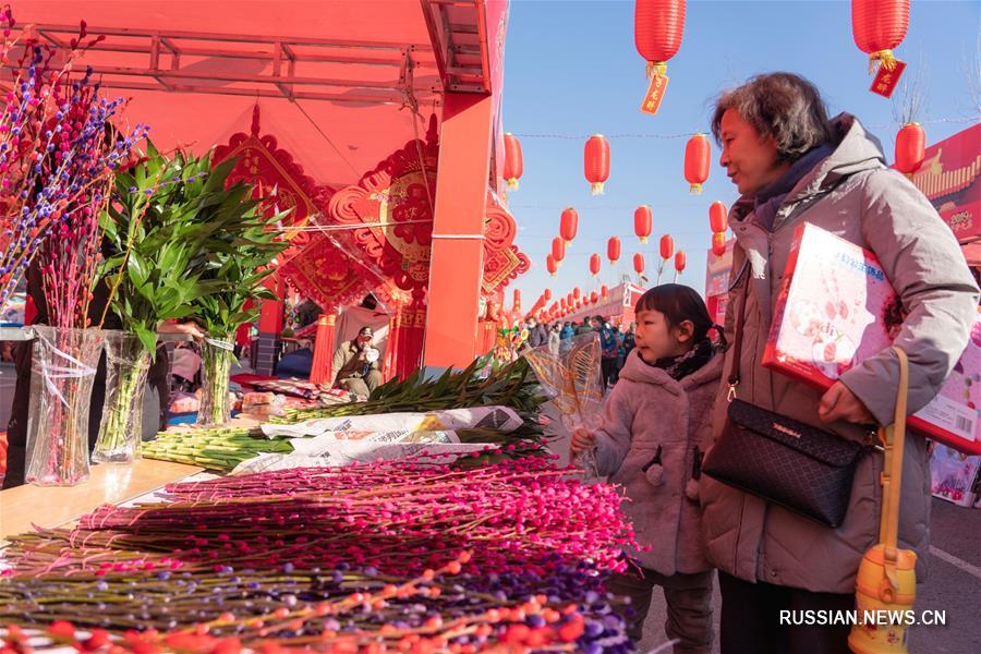 На фото -- новогодний рынок в поселке Чжэндин одноименного уезда провинции Хэбэй /Северный Китай/. 