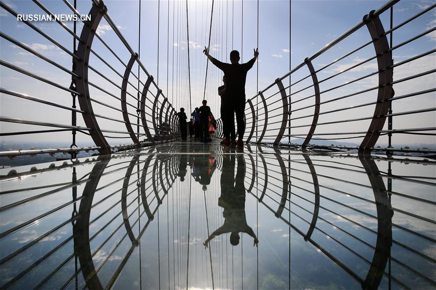 Туристы гуляли по стеклянному мосту на большой высоте в городе Цзянъинь