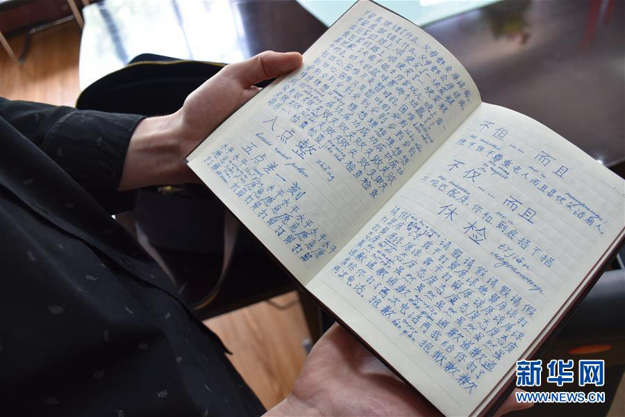 Ецю показывает корреспонденту написанные в тетради китайские иероглифы (фото сделано 4 июня).