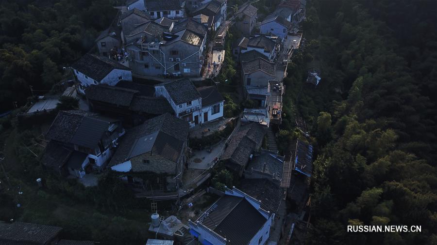 На фото -- окутанная предрассветной дымкой безмятежная деревня Мулихун, расположенная в горах уезда Сюнин провинции Аньхой /Восточный Китай/. 
