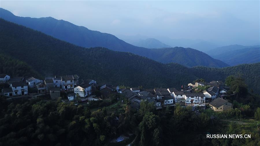 На фото -- окутанная предрассветной дымкой безмятежная деревня Мулихун, расположенная в горах уезда Сюнин провинции Аньхой /Восточный Китай/. 