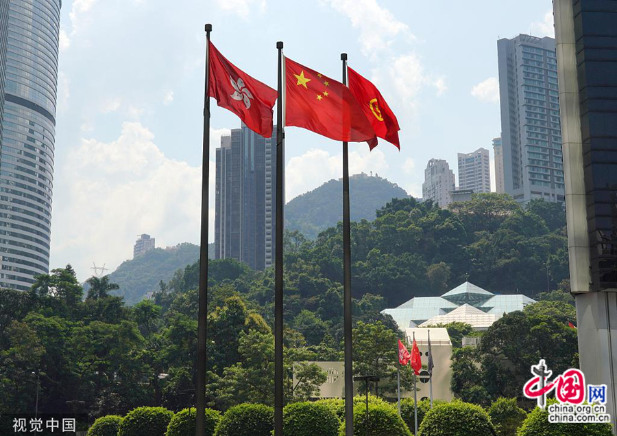 Торжественную атмосферу поддерживают растяжки с патриотичными слоганами и развевающиеся пятизвездочные красные государственные флаги КНР.