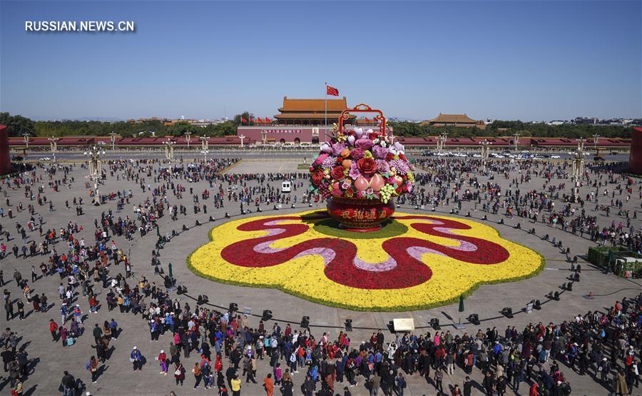Грандиозная цветочная композиция "Корзина с цветами и фруктами" на площади Тяньаньмэнь в центре Пекина привлекает внимание туристов и жителей столицы. 
