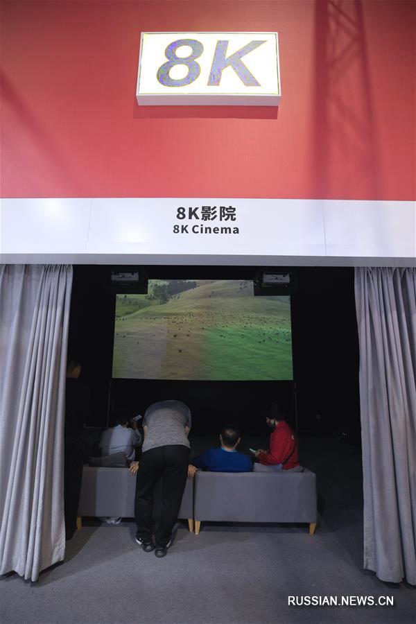 На фото -- зрители смотрят видео высокого разрешения в 8K-кинотеатре на стенде компании Sharp. 
