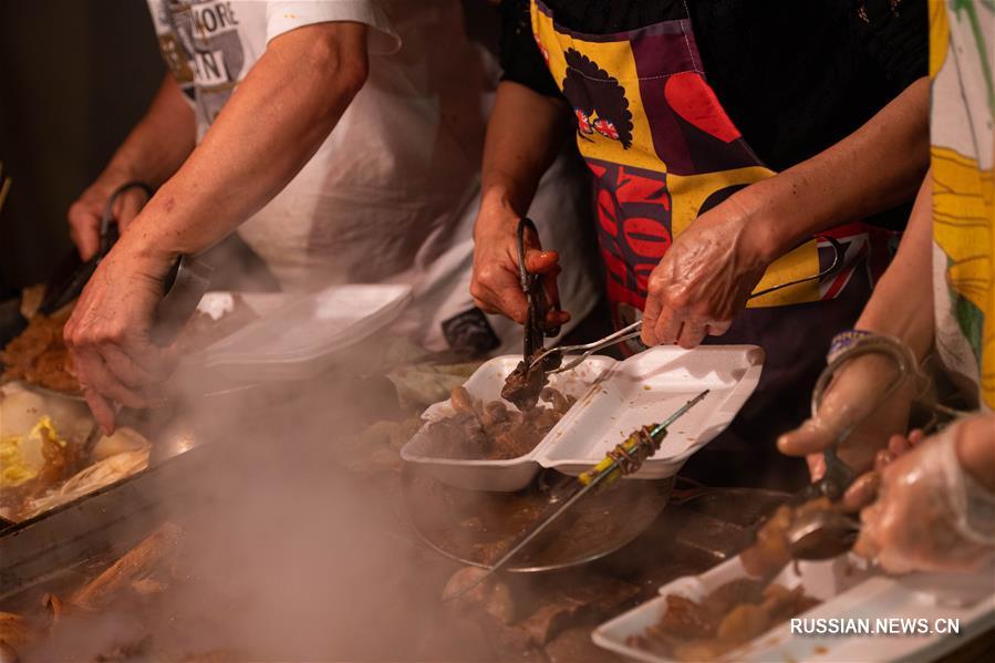На фото -- повара одного из уличных кафе в районе Синьмалу готовят для посетителей говяжьи потроха.
