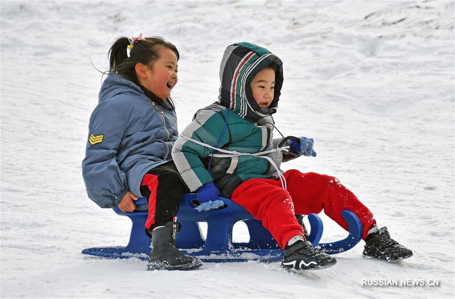 На снимке, сделанном 12 января этого года, дети катаются по снегу на одной из горнолыжных баз в г. Яньтай пров. Шаньдун /Восточный Китай/.