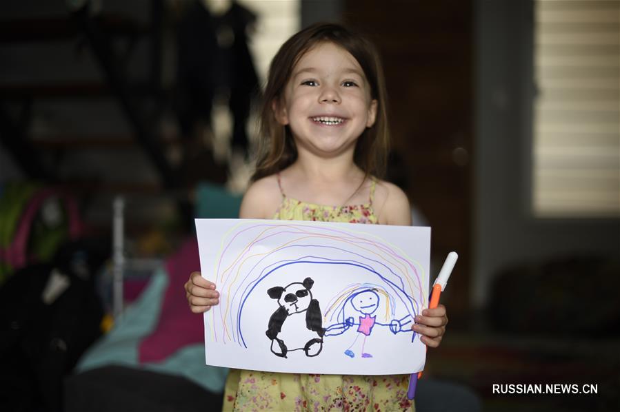  На фото от 8 февраля -- пятилетняя жительница Уругвая по имени Филиппа Родригес и ее рисунок, который она нарисовала в поддержку Китая, борющегося с эпидемией коронавирусной инфекции нового типа. 