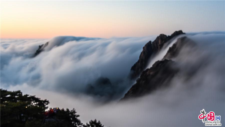 Море облаков и восход солнца после дождя на горах Хуаншань