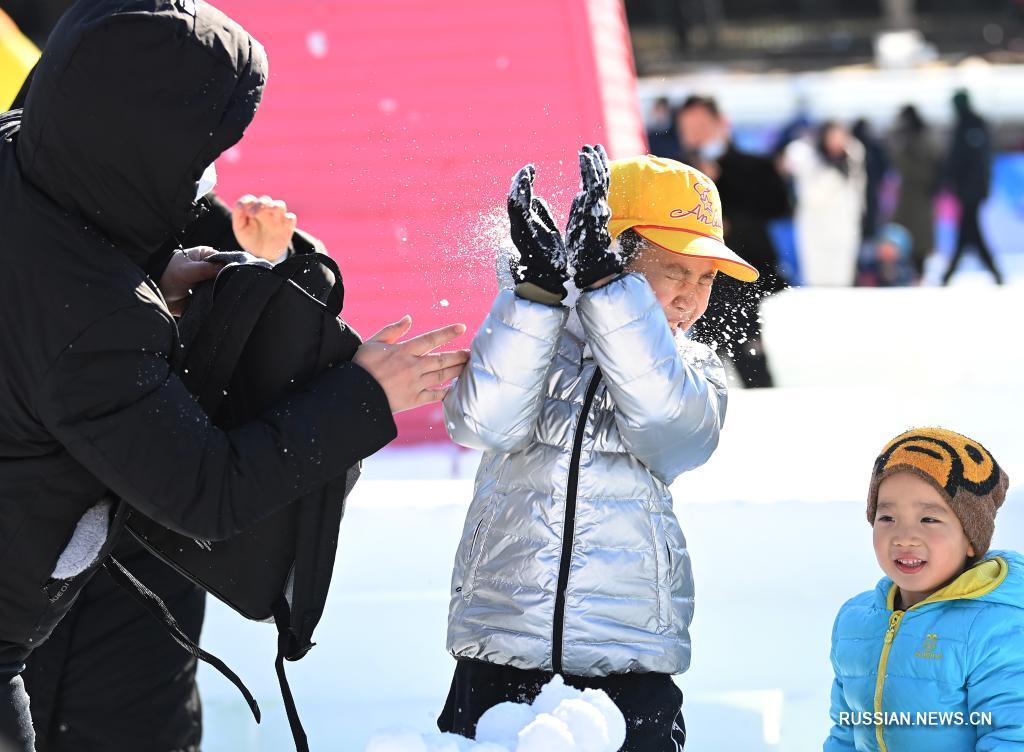 Дети играют со снегом во время ледяного и снежного карнавала, который проводится в парке Таожаньтин в новогодние праздники в Пекине 2 января 2022 года. 