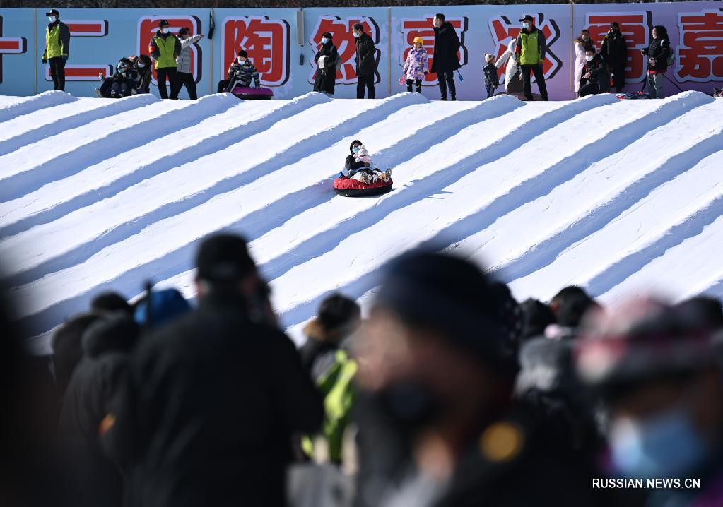 Люди покатаются на сноутюбинге во время ледяного и снежного карнавала, который проводится в парке Таожаньтин в новогодние праздники в Пекине 2 января 2022 года. 