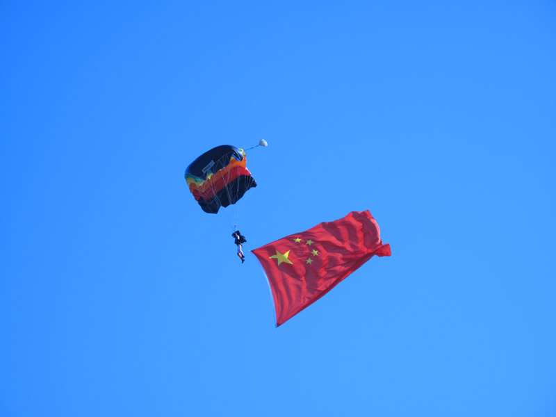 Photo taken on November 15 shows a flag of the PLA flows during a bailout performance of an air force show in Beijing Shahe airport. [Jiang Yiping/China.org.cn]