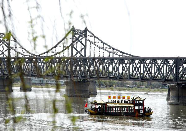 Tourists in the initial package tour group of the Sightseeing on the Liaoning Seashore Avenue take a pleasure boat to enjoy the scenery of the Yalujiang River in Dandong City, northeast China&apos;s Liaoning Province, May 7, 2010.