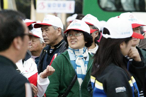 Tourists in the initial package tour group of the Sightseeing on the Liaoning Seashore Avenue arrive at the destination to enjoy the scenery of the Yalujiang River in Dandong City, northeast China&apos;s Liaoning Province, May 7, 2010. 