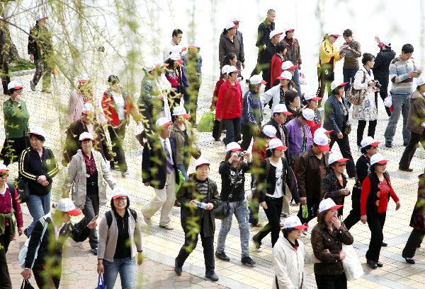 Tourists in the initial package tour group of the Sightseeing on the Liaoning Seashore Avenue promenade to enjoy the scenery of the Yalujiang River in Dandong City, northeast China's Liaoning Province, May 7, 2010. 