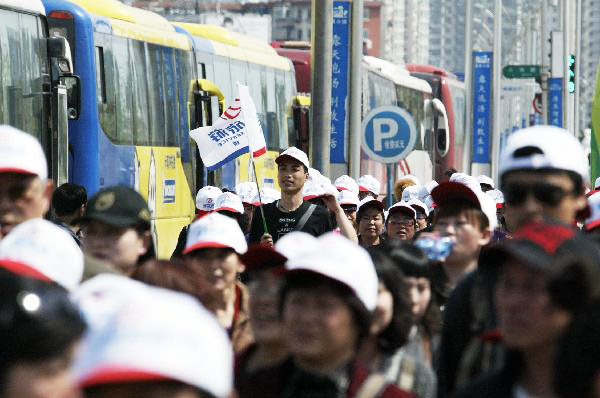  Tourists in the initial package tour group of the Sightseeing on the Liaoning Seashore Avenue arrive at the destination to enjoy the scenery of the Yalujiang River in Dandong City, northeast China's Liaoning Province, May 7, 2010. 