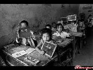 Students study in a cave and use stone boards as their notebooks in a village in Shaanxi province. 