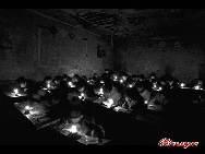  Students study by oil lamps in a village school in Shanxi province. 
