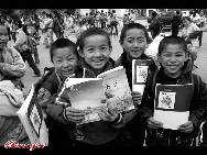  Students receive free textbooks at a village school in Guizhou province.