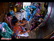 Women hang cloths as cradles for their babies.  The Bajau Laut, known as 'the Sea Gypsies,' live at the seaside of Malaysia and the Philippines. They build and live in tatty wooden sheds above the water and make a living by fishing. They have no access to education due to poverty and live on the margins of society. 