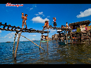 People build up simple bridges between the sheds for easier communication. The Bajau Laut, known as 'the Sea Gypsies,' live at the seaside of Malaysia and the Philippines. They build and live in tatty wooden sheds above the water and make a living by fishing. They have no access to education due to poverty and live on the margins of society.