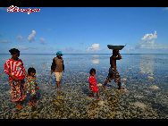 A family come back from fishing. The Bajau Laut, known as 'the Sea Gypsies,' live at the seaside of Malaysia and the Philippines. They build and live in tatty wooden sheds above the water and make a living by fishing. They have no access to education due to poverty and live on the margins of society.