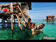  A woman feeds her child. The Bajau Laut, known as 'the Sea Gypsies,' live at the seaside of Malaysia and the Philippines. They build and live in tatty wooden sheds above the water and make a living by fishing. They have no access to education due to poverty and live on the margins of society.