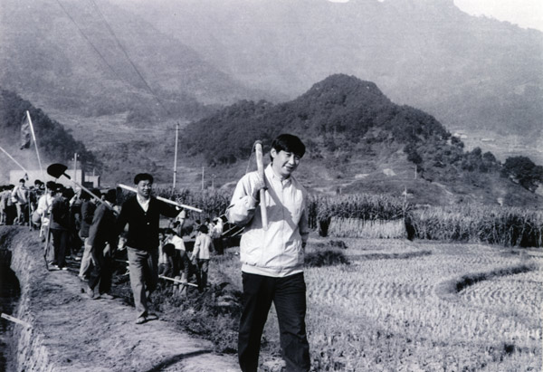 File photo taken in 1988 shows Xi Jinping (front), then secretary of the Ningde Prefecture Committee of the Communist Party of China (CPC), participates in farm work during his investigation in the countryside. [Photo/Xinhua]