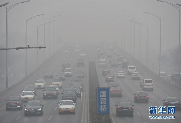 11月30日，汽车在北京东三环国贸桥上行驶。当日，北京全市遭遇严重污染天气。北京市气象台12时30分升级发布霾橙色预警信号，重度霾天气仍将持续。据北京市气象台下午发布的预报显示，11月30日夜间到12月1日白天北京地区空气污染气象条件均将为六级。[新华社 罗晓光 摄]