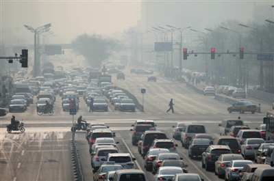 29日，西单，行人过马路。当天北京有雾霾。[新京报 薛珺 摄]