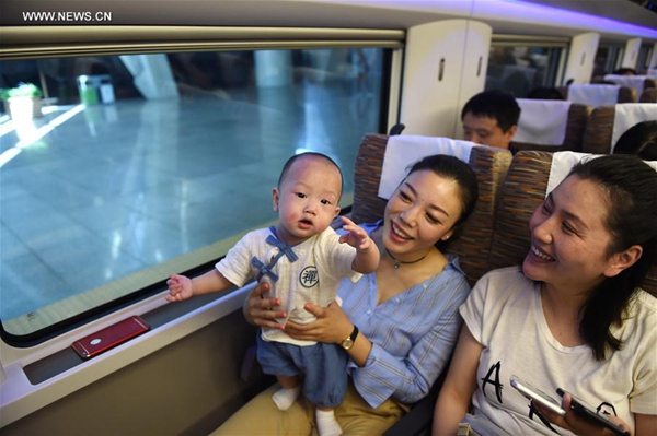Passengers board G123 train, a China&apos;s new high-speed train, in Beijing, capital of China, June 26, 2017. Two China-standard new high-speed trains, whose design and intellectual property rights are completely owned by China, started operation on Beijing-Shanghai high-speed railway line on Monday. [Photo/Xinhua]