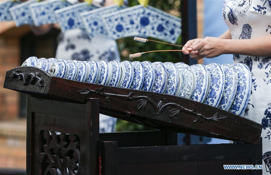 A performer plays Chinese traditional musical instrument made of porcelain during the opening ceremony of an exhibition of porcelain and ceramic from Jingde Town, China, as part of a serial culture event 'Experience China', at KPM porcelain manufacture in Berlin, capital of Germany, on July 5, 2017. [Photo/Xinhua]