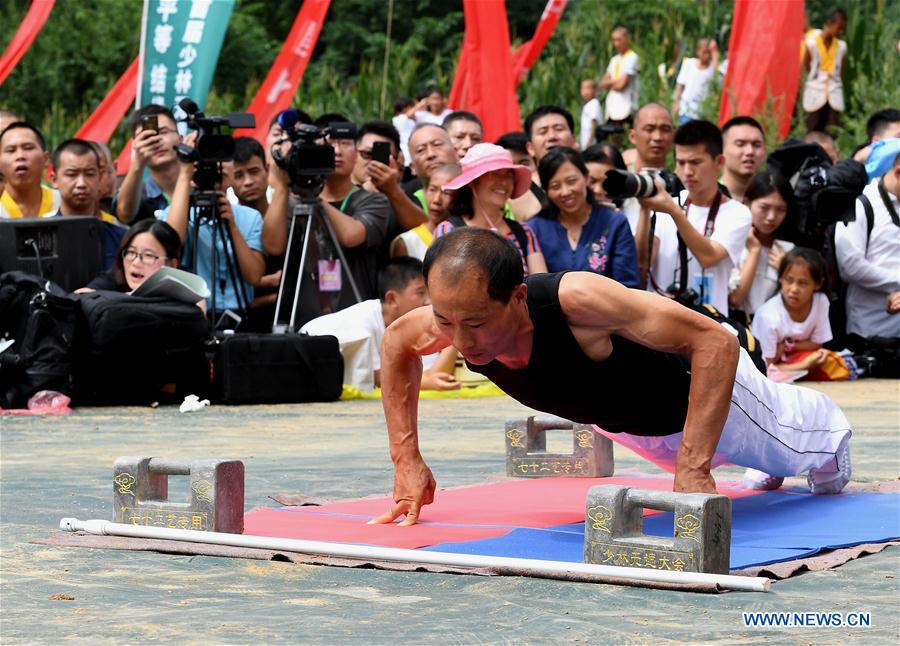 A contestant performs in the Two-Finger Zen category during a martial arts competition held in Shaolin Temple, central China&apos;s Henan province, July 30, 2017. The competition features four traditional events of Iron Palm Kungfu, Stone Lock Kungfu, Two-Finger Zen and Flying Knife Kungfu. (Xinhua/Li An)