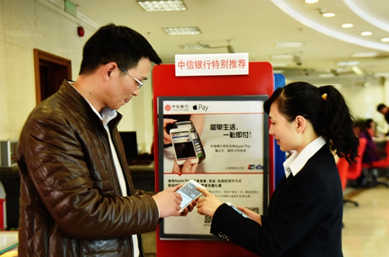A man learns how to use Apple Pay at a bank in Hangzhou, capital of Zhejiang province. [Photo/China Daily]