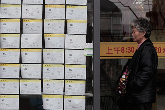 A citizen checks house leasing information on Xiangyang Road, Shanghai.[Photo/China Daily]