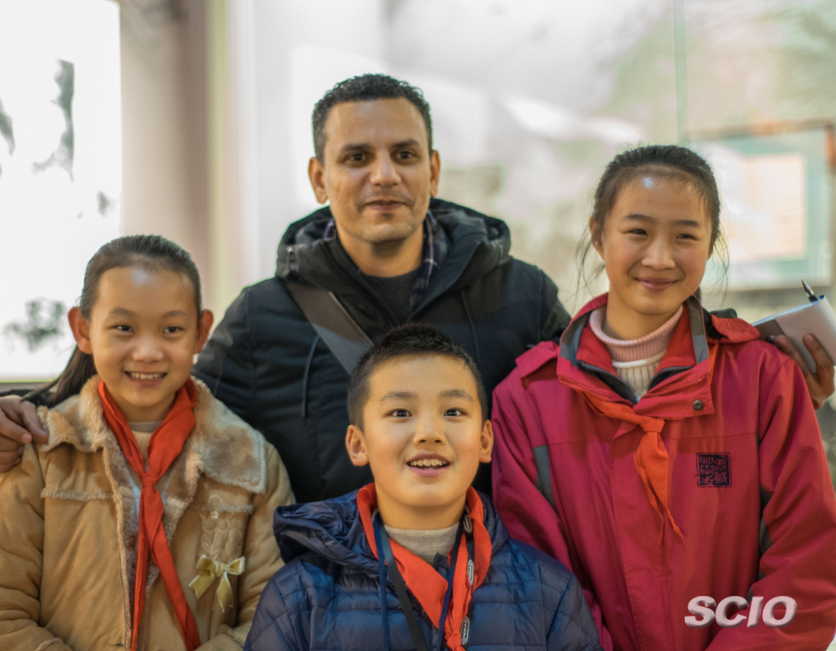 A foreign journalist takes photos with Yuan Changjie and two other friends who also volunteer to act as tour guides at the Zunyi Conference Memorial Museum. [Photo by Sun Tao/China.org.cn]