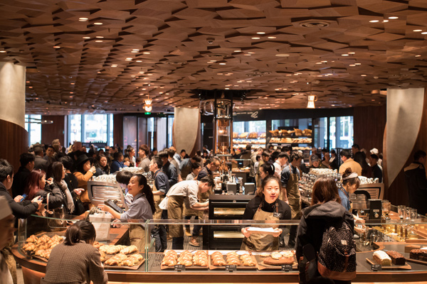 Customers select beverages and food items at the Starbucks Reserve Roastery in Shanghai. The store, which covers 2,700 square meters, is its largest outlet in the world. [Photo/China Daily]