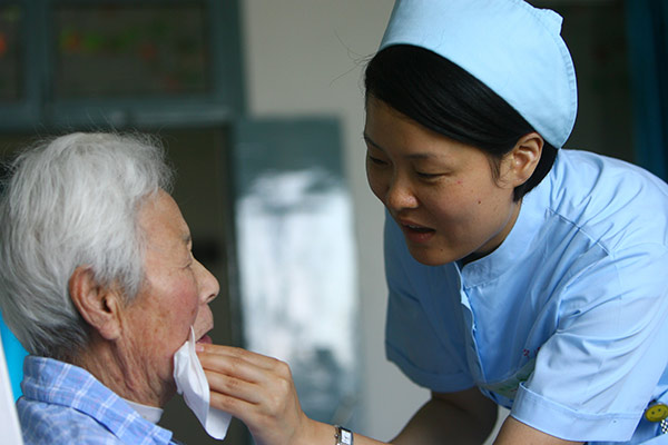 A nurse takes care of an elderly patient at a Kangning Hospital in Ningbo, Zhejiang province. The hospital belongs to the largest private psychiatric healthcare group in China.[Photo provided to China Daily]