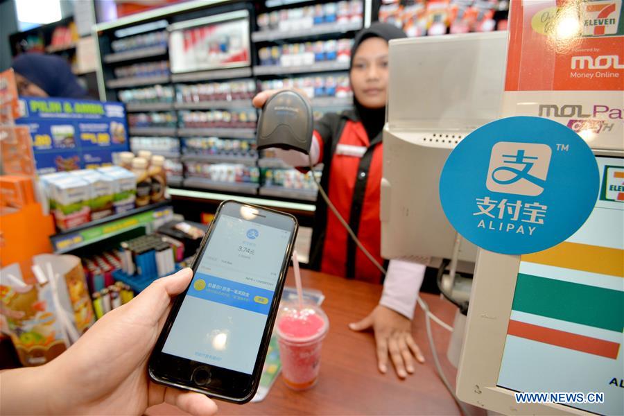 A customers uses Alipay to pay for his pill at a shop in Kuala Lumpur, Malaysia, July 24, 2017. [Photo/Xinhua]