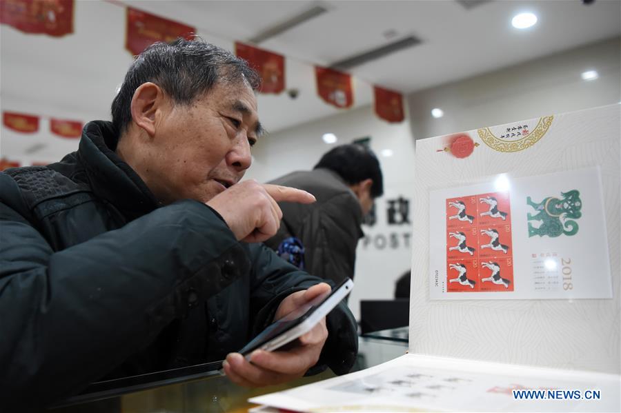 A citizen buys zodiac stamps for the Year of the Dog in southwest China's Chongqing Municipality, Jan. 5, 2018. China Post issued a set of special zodiac stamps for the Year of Dog with two different designs Friday. The Year of Dog, or Chinese traditional lunar New Year of this year, starts from Feb. 16. [Photo/Xinhua]