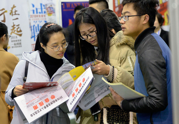 Job seekers check recruitment information at a job fair held in Hangzhou, capital of Zhejiang province. [Photo/China Daily] 