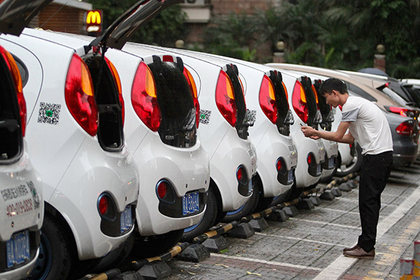 A customer in Guangzhou, Guangdong province, scans the code of Gofun shared cars from Shouqi Group. [Photo/China Daily]