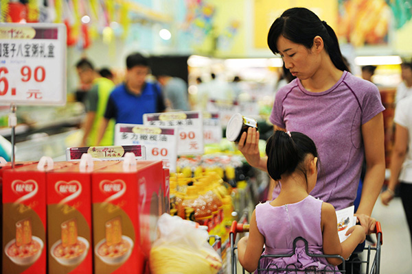 A woman chooses canned food at a supermarket in Qingdao, East China's Shandong province, Sep 9, 2016. [Photo/China Daily]