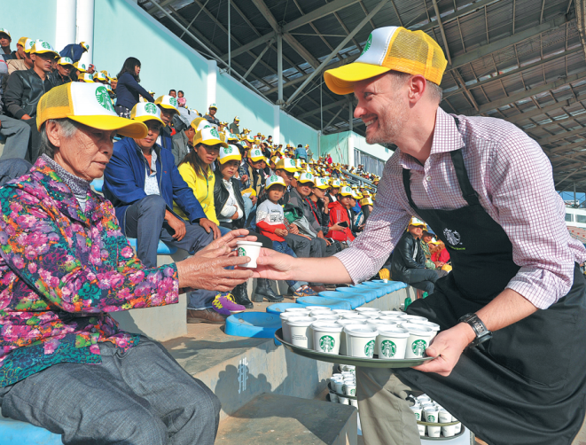 A barista from Starbucks serves brewed coffee to farmers in Yunnan province. [Photo provided to China Daily]