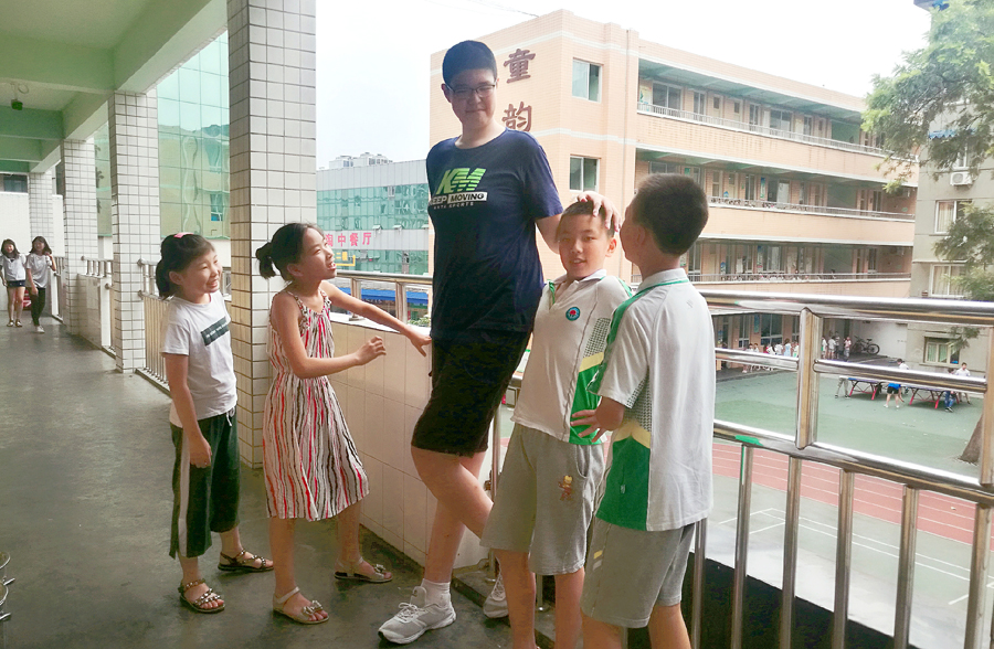 Ren Keyu, a 2.06-meter-tall primary school student, hangs out with classmates in Leshan, Sichuan province, on Monday.[Photo/Chengdu Economic Daily]