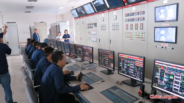 Employees in the control room monitor data from the Shanxi Xinshitai Green Energy power plant. [Photo by Chris Georgiou / China.org.cn]
