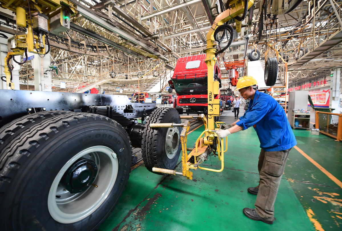 A technician installs tires at an automobile manufacturing plant in Xi'an, capital of Shaanxi province. [Photo/Xinhua]