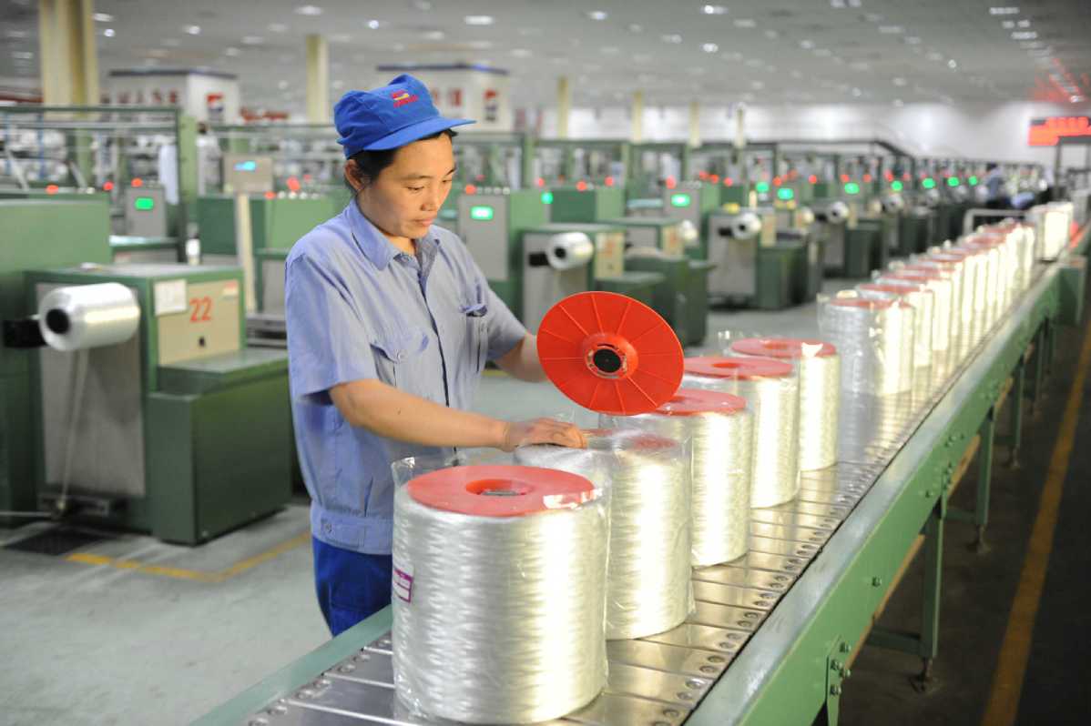A worker packages glass fiber products at China Jushi Co Ltd's factory in Jiujiang, Jiangxi province. [Photo/China Daily]