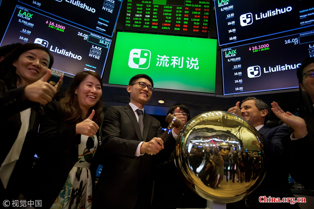 Yi Wang (center), founder and chief executive officer of Laix Inc., rings a ceremonial bell during the company's initial public offering on the floor of the New York Stock Exchange in New York, U.S., Sept. 27, 2018. [Photo/China.org.cn]
